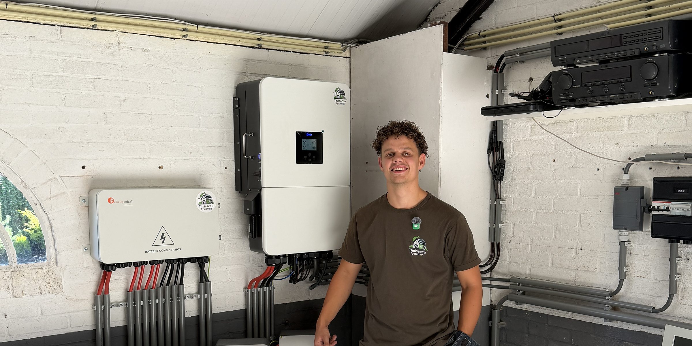 Melle Brouwers bij een zakelijke installatie met vier accu's en een hybride omvormer