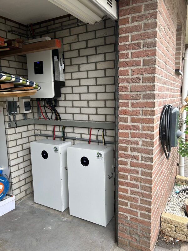 Twee LiFePO4 thuisaccu's met Deye omvormer op een bakstenen muur