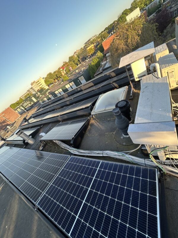 Zonnepanelen op een plat dak bij zonsondergang